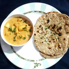 A picture of Paneer Butter Masala with Tava Naan.