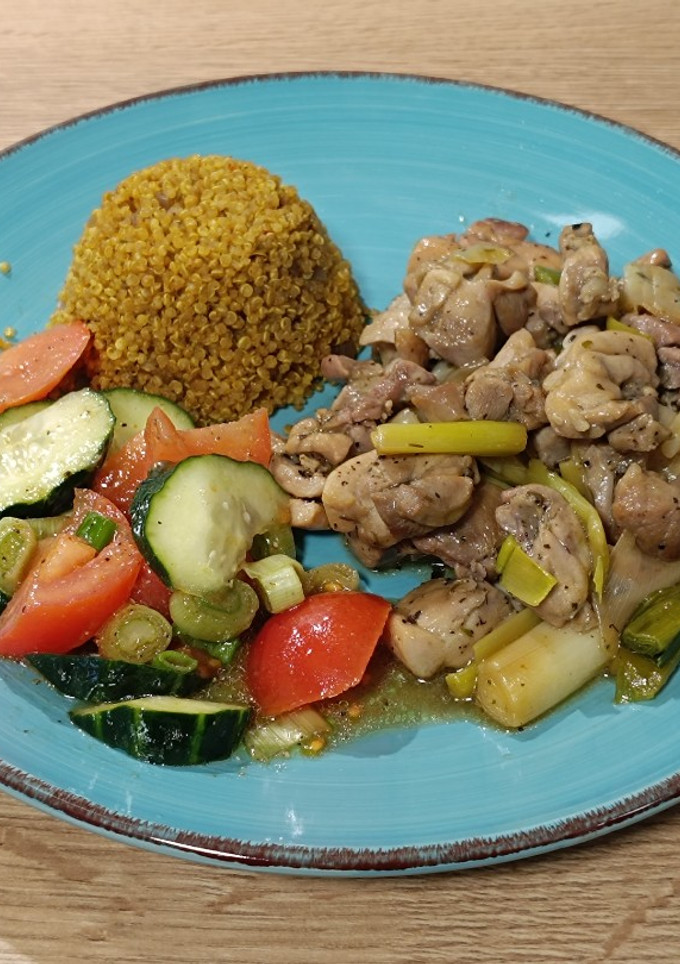 Una foto de Wok de pollo con ajetes tiernos y una quinoa al curry de guarnición