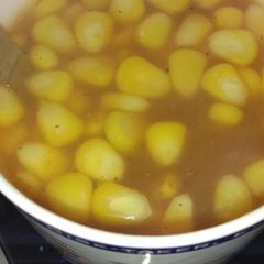 A picture of Tomato soup with sweet corn.