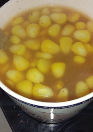 A picture of Tomato soup with sweet corn.
