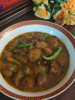 A picture of Moong daal Mangochian (fried lentils balls in curry).