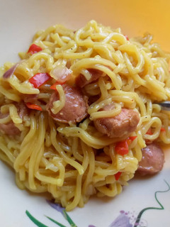 A picture of Indomie noodles with sausage.