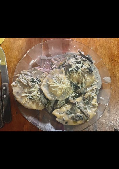 Una foto de Pasta rellena de ricota casera con crema de champiñones
