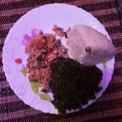 A picture of Scrambled eggs with ugali and kales.