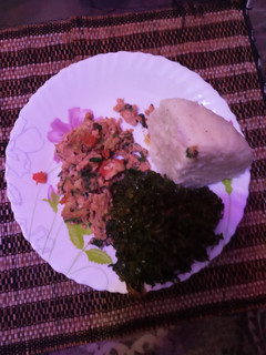 A picture of Scrambled eggs with ugali and kales.