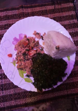 A picture of Scrambled eggs with ugali and kales.