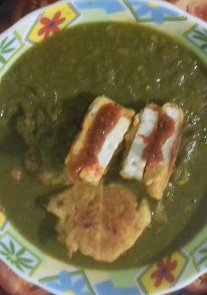 A picture of Paneer sandwich in spinach gravy.