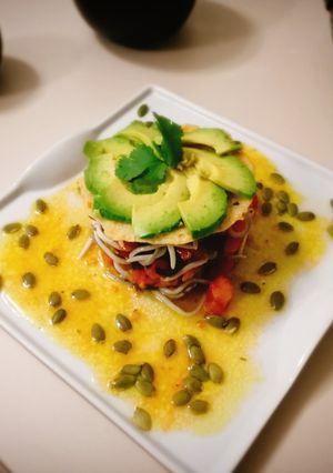 Una foto de Tartar de tomate, crujiente de aceite, flor de aguacate y vinagreta de mostaza