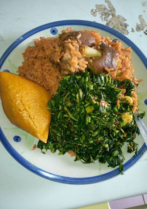 A picture of Jollof rice with vegetable sauce.