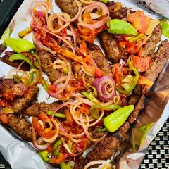 A picture of Baked Seekh kabab with tomatoes.