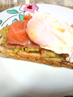 Una foto de Tostada con aguacate, salmón y huevo poche