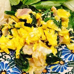 A picture of Scrambled eggs with bacon and spinach.