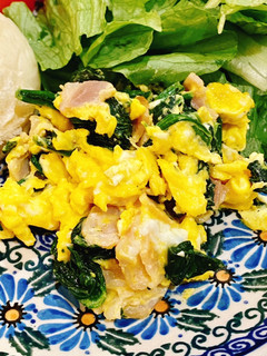 A picture of Scrambled eggs with bacon and spinach.