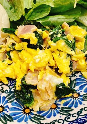 A picture of Scrambled eggs with bacon and spinach.