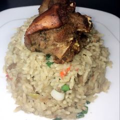 A picture of Coconut rice with fried goat meat.