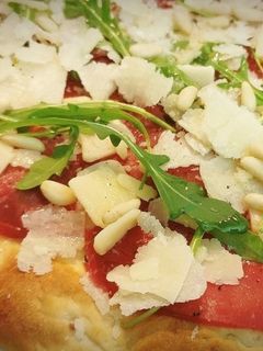 Una foto de Pizza de Carpaccio de Ternera, con Rúcula y Piñones