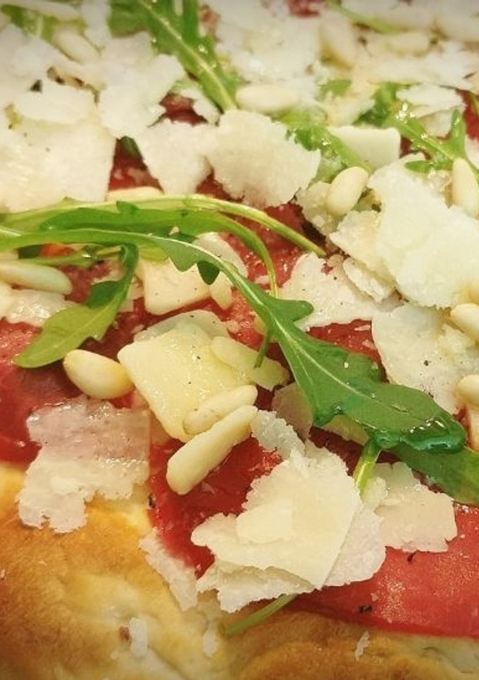 Una foto de Pizza de Carpaccio de Ternera, con Rúcula y Piñones