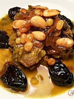 Una foto de Lomo de cordero, con cebollas caramelizda, cirulas, pasas y crujiente de almendras