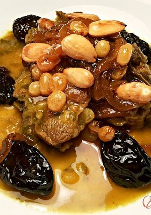 Una foto de Lomo de cordero, con cebollas caramelizda, cirulas, pasas y crujiente de almendras