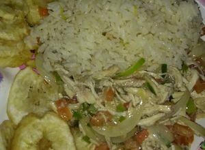Una foto de Pollo desmechado con vegetales, arroz y tajadas de plátano verde
