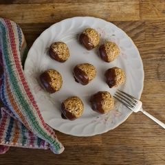 A picture of Oat and date balls with dark chocolate.