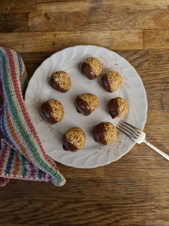 A picture of Oat and date balls with dark chocolate.