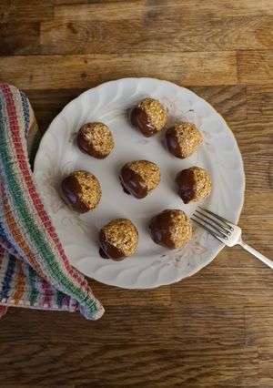 A picture of Oat and date balls with dark chocolate.