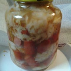 A picture of Sweet and sour cabbage with hotdogs.