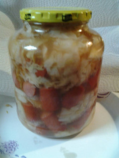 A picture of Sweet and sour cabbage with hotdogs.