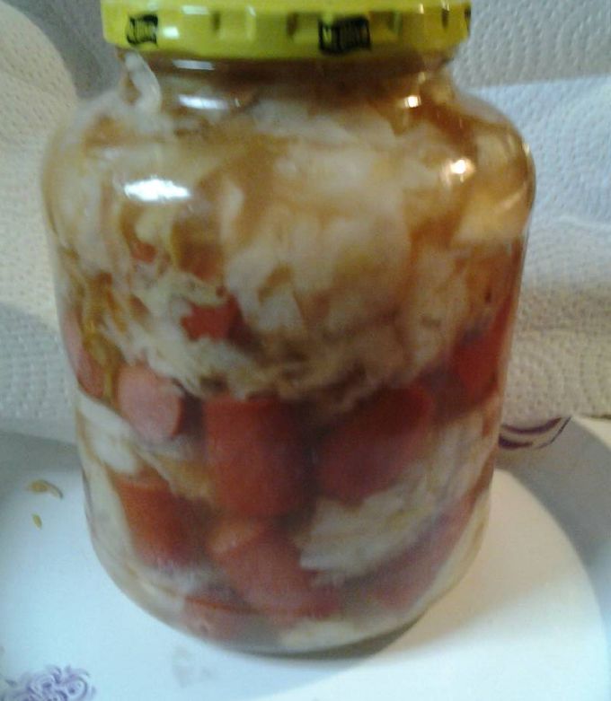 A picture of Sweet and sour cabbage with hotdogs.