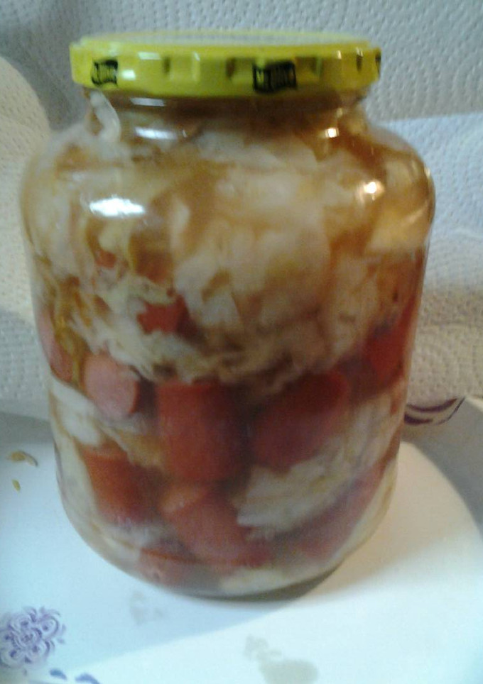 A picture of Sweet and sour cabbage with hotdogs.