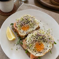 A picture of Smoked Salmon & Egg Toast with Arugula and Sprouts.
