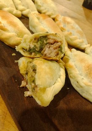 Una foto de Espanadas de espinaca, carne y salsa blanca