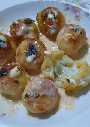 Una foto de Ñoquis bolita rellenos con quesos y salsa de quesos