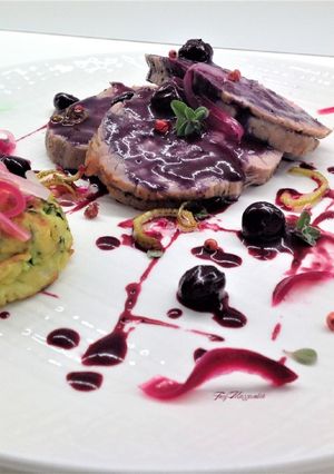 A picture of Roasted Veal Loin with Flavored Coarse Salt, Blueberry Sauce, and Zucchini Fritters.