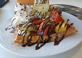 Waffle completo com topping de chocolate, bolacha crocante e gelado de baunilha