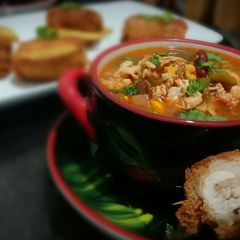 A picture of Chicken fajita soup with chicken pin rolls and cheesy potatoes.
