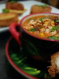 A picture of Chicken fajita soup with chicken pin rolls and cheesy potatoes.