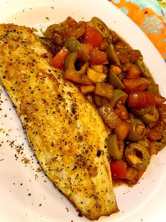 Una foto de Lubina citrica con vinagreta de tomate y aceitunas