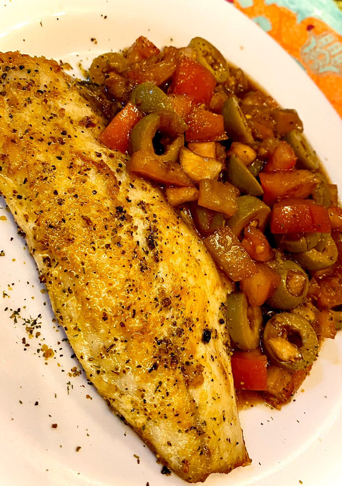 Una foto de Lubina citrica con vinagreta de tomate y aceitunas