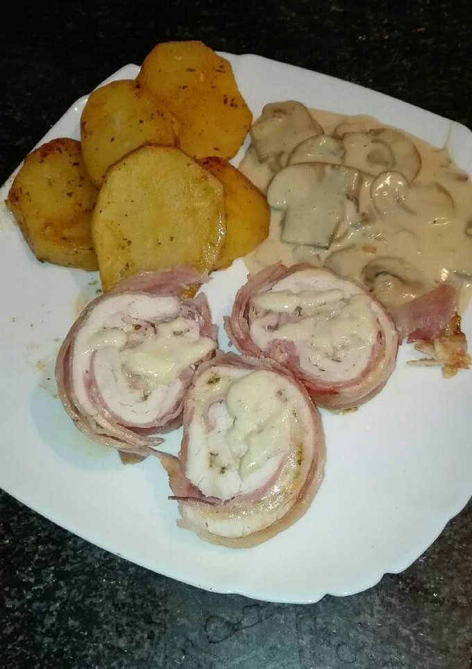 Una foto de Rollo de pechuga envuelto en beicon y relleno de jamón York y queso con salsa de champiñones y almendras