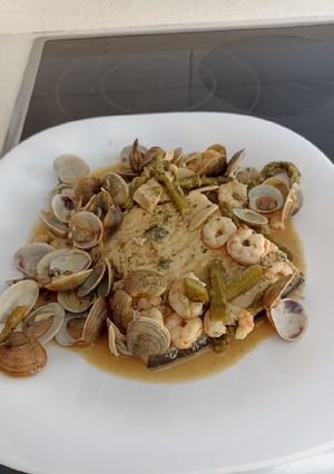 Una foto de Pez espada con gambas, almejas y espárragos
