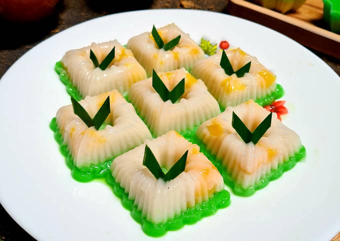 Potongan kue lapis nangka berlapis warna kuning dan putih tersaji di atas piring