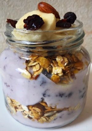 Una foto de Parfait de yogur en frasco con granola, frutos secos y banana😋