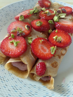 Una foto de Crepes de espelta con queso batido, mermelada y pistachos