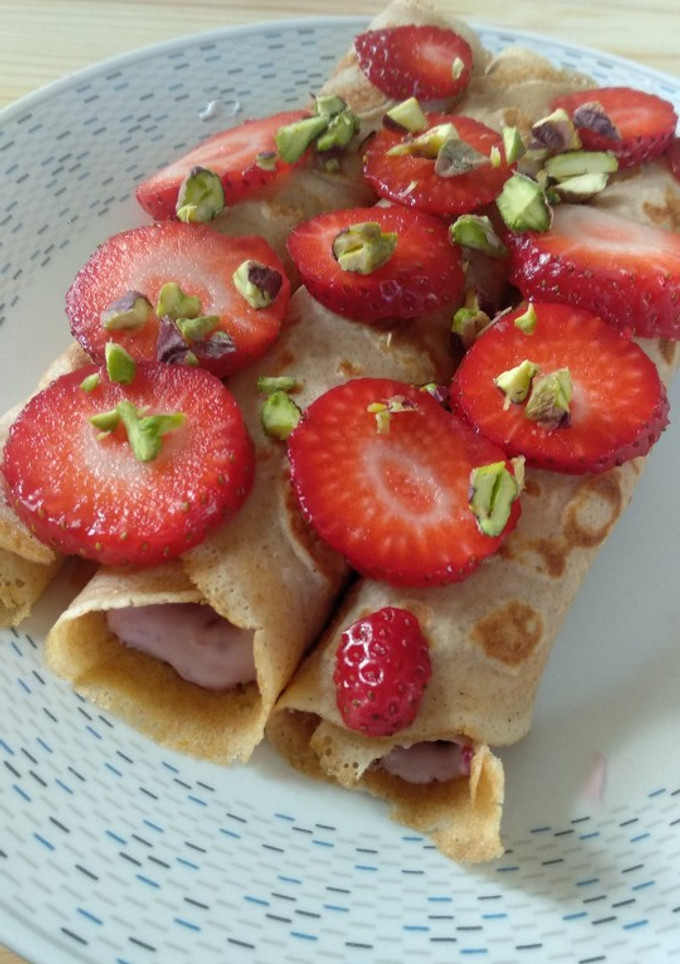 Una foto de Crepes de espelta con queso batido, mermelada y pistachos