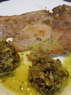 Una foto de Cabecero de cerdo a la plancha, con alcachofas al ajillo y salsa alkale