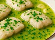 Una foto de pescado en salsa verde