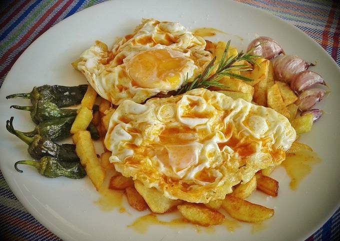Foto principal de Huevos fritos con patatas, ajos enteros y pimientos de padrón