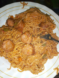 A picture of Tasty fried indomie noodles with sausages.